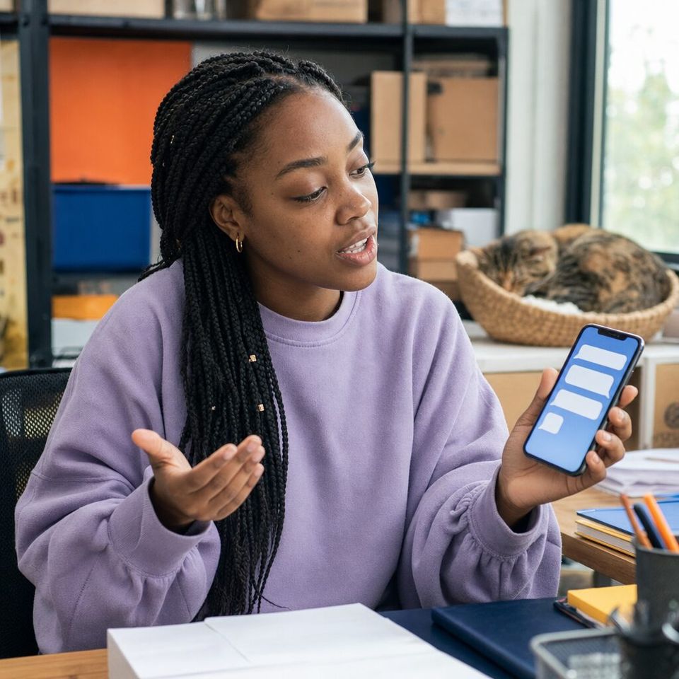 Illustrative photo: the customer-support lead at an online pet-supplies shop asks the Prompt Engineer for help from their phone.